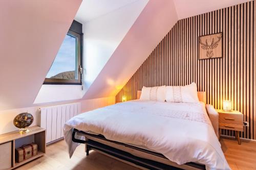 a bedroom with a large bed and a staircase at Cocon de Luchon - Station de ski accessible à pied in Luchon