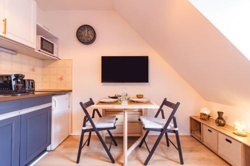 une cuisine avec une table avec des chaises et une télévision dans l'établissement Cocon de Luchon - Station de ski accessible à pied, à Luchon