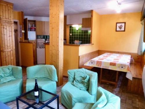 - une cuisine avec 2 chaises et une table avec une bouteille de vin dans l'établissement Résidence Oncet - Appartement 6 couchages, dans le centre de Barèges MAE-8394, à Barèges