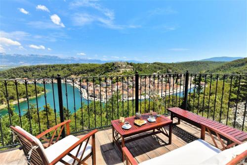 a balcony with a table and chairs and a view of a river at Dreamview & heated pool at Lucija 1 in Novigrad Dalmatia