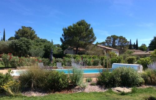 un jardín con piscina en un patio en Mazet de la Lavande en Uzès