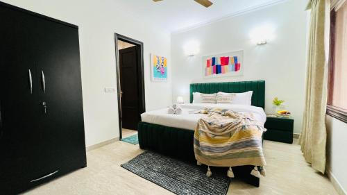 um quarto com uma cama com uma cabeceira verde em BluO Vasant Vihar PVR - Terrace Garden, Lift em Nova Deli