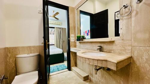 uma casa de banho com um lavatório, um WC e um espelho. em BluO Vasant Vihar PVR - Terrace Garden, Lift em Nova Deli