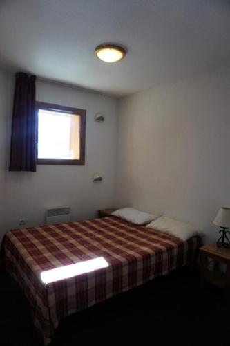 une petite chambre avec un lit et une fenêtre dans l'établissement Résidence Cristallines - 2 Pièces 4 Personnes MAE-9380, à Orcières