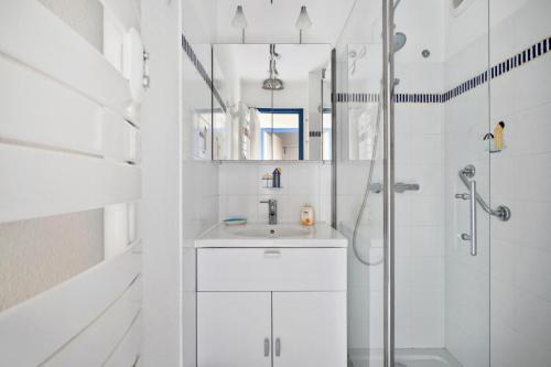 une salle de bain blanche avec une douche et un lavabo dans l'établissement Résidence Port du Crouesty - maeva Home - Appartement 2 pièces 4 personnes - Sélection MAE-1249, à Arzon