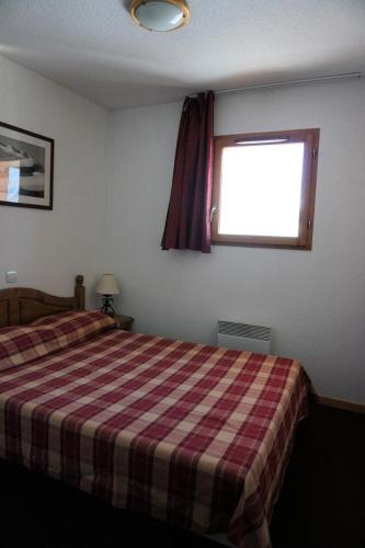 - une chambre dotée d'un lit avec une couverture tressée et une fenêtre dans l'établissement Résidence Cristallines - 2 Pièces cabine 6 Personnes MAE-9375, à Orcières