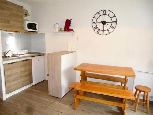 une cuisine avec une table, un banc et une horloge dans l'établissement Résidence Rioulet - Joli studio avec balcon et parking proche du centre de Barèges MAE-8494, à Barèges