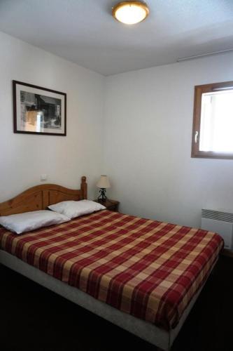- une chambre avec un grand lit et une couverture rayée dans l'établissement Résidence Cristallines - 2 Pièces cabine 6 personnes MAE-9692, à Orcières