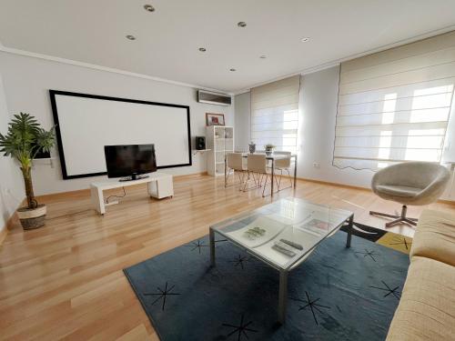 a living room with a flat screen tv and a couch at Dúplex Valle del Silencio in Ponferrada