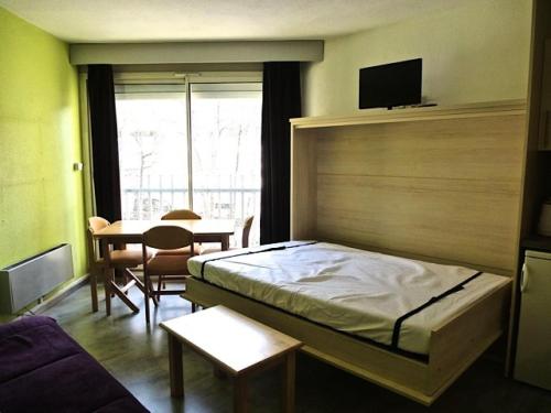 une chambre avec un lit, une table et une télévision dans l'établissement Résidence Ayre - Studio exposé sud proche du centre de Barèges MAE-8514, à Barèges