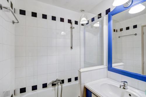 une salle de bain avec une baignoire, un lavabo et un miroir dans l'établissement Résidence Cap Marine - maeva Home - Duplex 2 Pièces 4 Personnes - Sélection MAE-1676, au Guilvinec