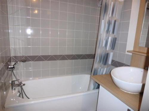 uma casa de banho com uma banheira branca e um lavatório. em Résidence Bois De Marie - 4 Pièces pour 7 Personnes 564 em Barèges