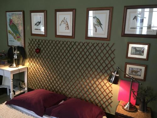 a bedroom with a bed and framed pictures on the wall at "Chambre d'Autres", massages in Montpellier