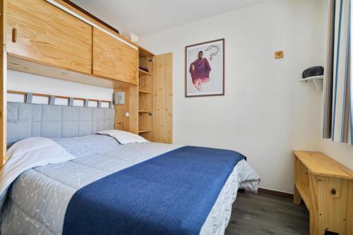 une chambre avec un lit bleu et blanc et un bureau dans l'établissement Port du Crouesty Cap'Océan - maeva Home - 2 pièces 4 personnes - Sélection - vue sur le Port MAE-1693, à Arzon