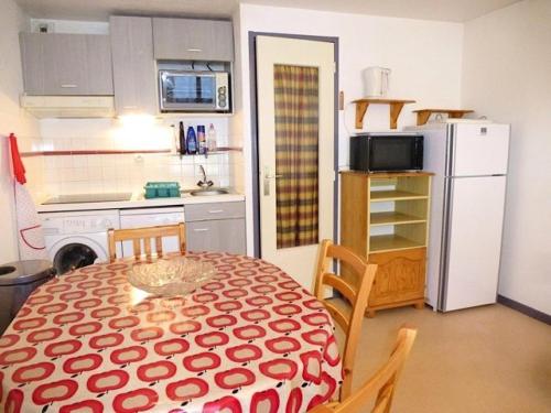 Il comprend une petite cuisine avec une table et un réfrigérateur blanc. dans l'établissement Résidence Artigalas - Appartement avec parking dans le centre de Barèges MAE-8584, à Barèges