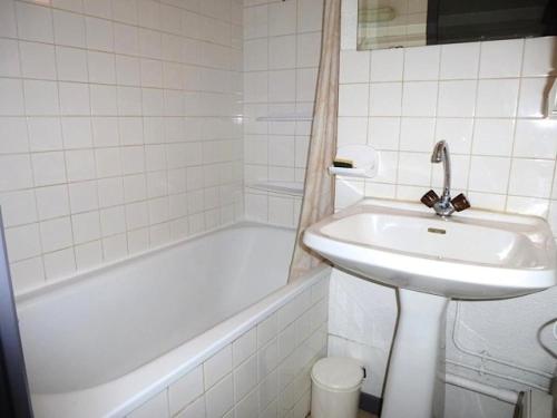 a white bathroom with a sink and a bath tub at Résidence Artigalas - Appartement avec parking dans le centre de Barèges MAE-8584 in Barèges