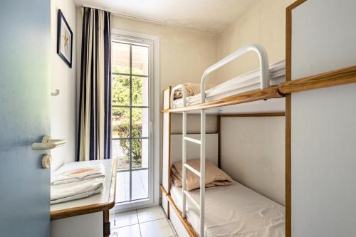 Cette petite chambre comprend des lits superposés et une fenêtre. dans l'établissement Résidence Port Bourgenay - maeva Home - Appartement 2 pièces 7 personnes - Sélection MAE-2020, à Talmont-Saint-Hilaire