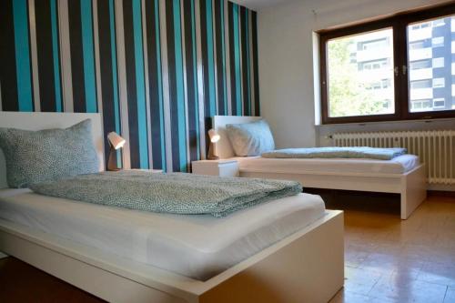 een slaapkamer met 2 bedden en een raam bij ATRIUM - geräumige Wohnung GIESEN in Oftersheim