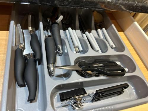 a drawer filled with knives and other kitchen utensils at Spacious 2 Bed 2 Shower Apartment in Crewe