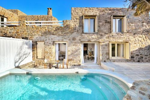 une villa avec une piscine en face d'un bâtiment dans l'établissement Mykonos Dream Villas, à Ftelia