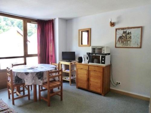 - un salon avec une table et un four micro-ondes dans l'établissement Résidence Ecureuils - Studio avec parking couvert proche du centre de Barèges MAE-8634, à Barèges