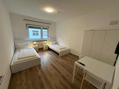 een kleine kamer met 2 bedden en een tafel bij ATRIUM - großzügige Wohnung BLÜCHER 2 in Ludwigshafen am Rhein
