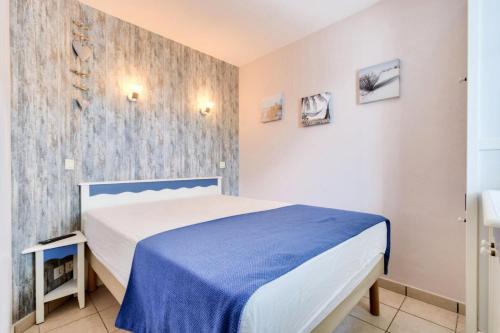 une chambre avec un lit bleu et blanc dans une pièce dans l'établissement Résidence Port Bourgenay - maeva Home - 2 Pièces 4 Personnes Selection MAE-2072, à Talmont-Saint-Hilaire