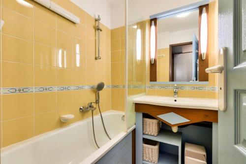 une salle de bain avec une baignoire, un lavabo et un miroir dans l'établissement Résidence Port Bourgenay - maeva Home - 2 Pièces 4 Personnes Selection MAE-2072, à Talmont-Saint-Hilaire