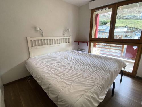 a white bed in a bedroom with a window at Résidence Bois De Marie - 3 Pièces pour 5 Personnes 644 in Barèges