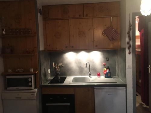 une cuisine avec un évier et un micro-ondes dans l'établissement Résidence Betelgeuse - Studio cabine 3 personnes exposé est MAE-7844, à Valloire