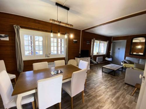 une salle à manger avec une table et des chaises blanches dans l'établissement Chalet Ufia - Bel appartement dans un ancien chalet rénové proche du centre de Barèges MAE-8674, à Barèges
