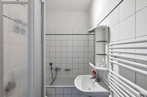 y baño blanco con lavabo y bañera. en Gründerzeitvilla in Potsdam, en Potsdam