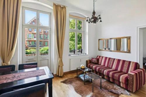 un soggiorno con divano e 2 finestre di Gründerzeitvilla in Potsdam a Potsdam