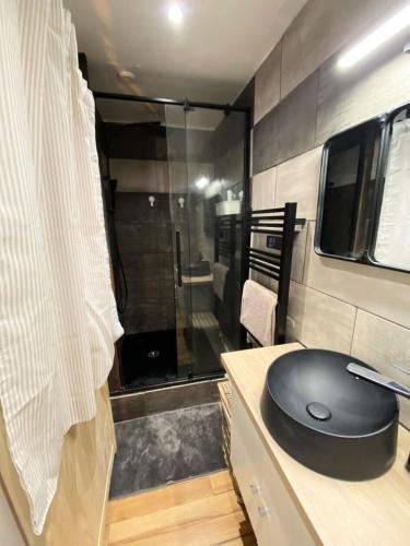une salle de bains avec une souris d'ordinateur noire sur un comptoir dans l'établissement Résidence Rioulet 1 - Très beau studio avec mezzanine et balcon proche du centre de Barèges MAE-1124, à Barèges