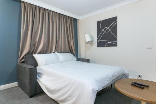 a hotel room with a bed and a table at Hotel styling entire one bedroom in Sydney
