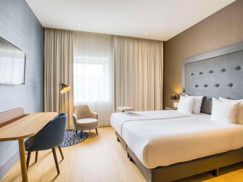 um quarto de hotel com uma cama grande e uma secretária em Mercure Hotel Amersfoort Centre em Amersfoort