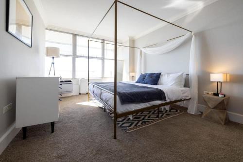 a bedroom with a canopy bed in a white room at CozySuites 800 Tower 2BR w/sky pool, gym! 32 in Louisville