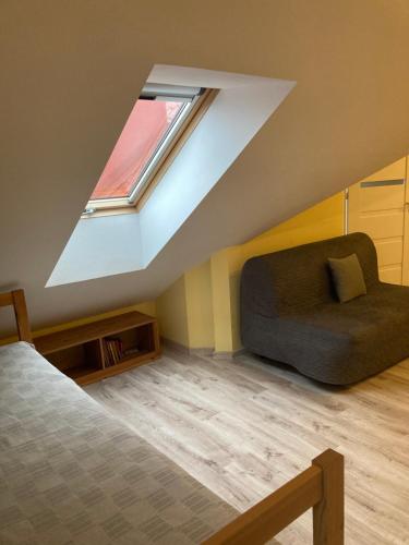 カルビアにあるNa Fali Apartament w Karwiのベッドと窓が備わる屋根裏部屋