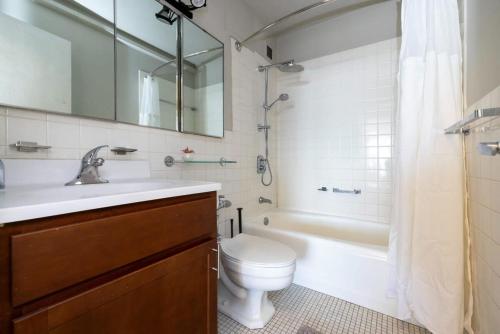a bathroom with a toilet and a tub and a sink at CozySuites 800 Tower 2BR w/sky pool, gym! 32 in Louisville