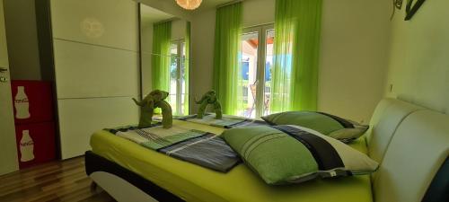 a bedroom with green walls and a bed with dolls on it at Villa Kasandra in Kaštel