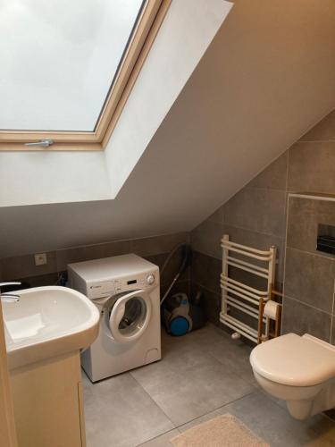 a bathroom with a washing machine and a sink at Na Fali Apartament w Karwi in Karwia