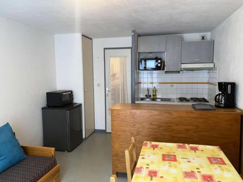 Il comprend une petite cuisine avec une table et une table. dans l'établissement Résidence Artigalas - Appartement 4 couchages dans le centre de Barèges MAE-6944, à Barèges