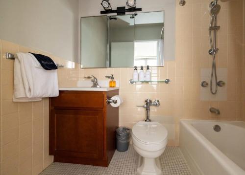 een badkamer met een wastafel, een toilet en een bad bij CozySuites 800 Tower 2BR with sky pool gym 33 in Louisville