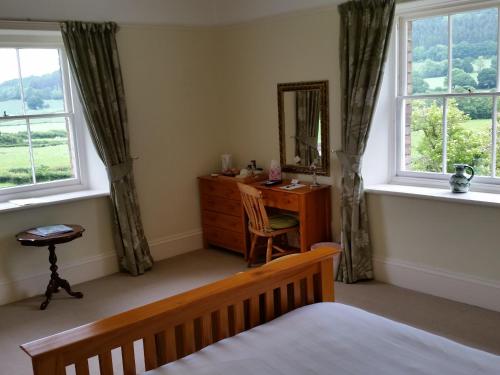 Schlafzimmer mit einem Bett, einer Kommode und einem Spiegel in der Unterkunft Upper Letton Farm in Leintwardine