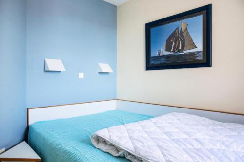 - une chambre avec un lit avec une photo de voilier sur le mur dans l'établissement Résidence Port Bourgenay - maeva Home - 2 pièces 5 personnes Sélection MAE-2715, à Talmont-Saint-Hilaire
