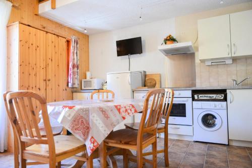 une cuisine avec une table et des chaises et un micro-ondes dans l'établissement Résidence La Demeurance - 2 pièces cabine + mezzanine 6 personnes 2 exposé ouest MAE-7934, à Valloire