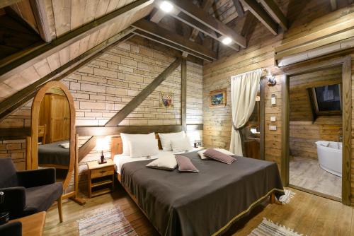 a bedroom with a large bed and a bath tub at Lakeside Hotel Plitvice in Plitvička Jezera