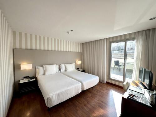 バルセロナにあるゼニット バルセロナの大型ベッドとテレビが備わるホテルルームです。