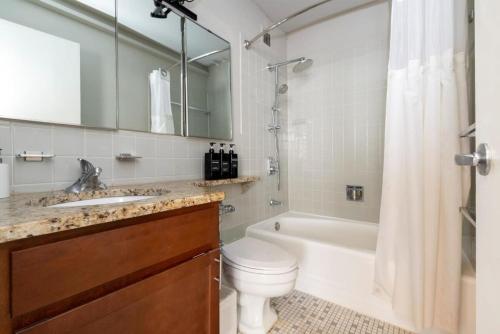 a bathroom with a tub and a toilet and a sink at CozySuites 800 Tower 2BR w sky pool gym 31 in Louisville