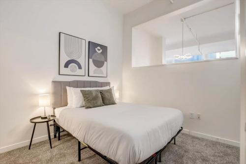 a white bedroom with a bed and a window at CozySuites - 1BR with Direct Skybridge Access #2 in Indianapolis